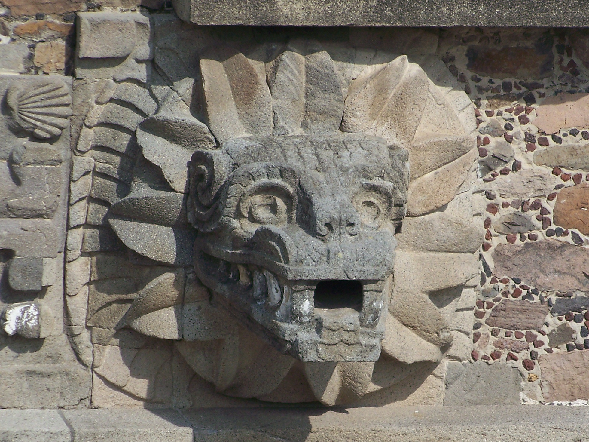 A projecting stone serpent head at Teotihuacan, surrounded by a carved feather collar.
