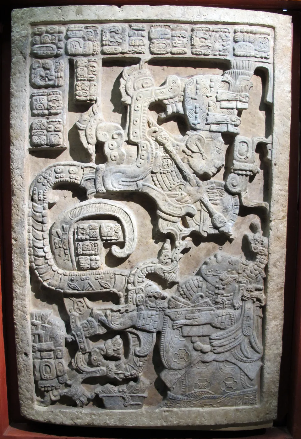 Lady K'ab'al Xook faces a large visionary serpent rising from a vessel; a human figure appears in the serpent's open mouth on Yaxchilan Lintel 25.