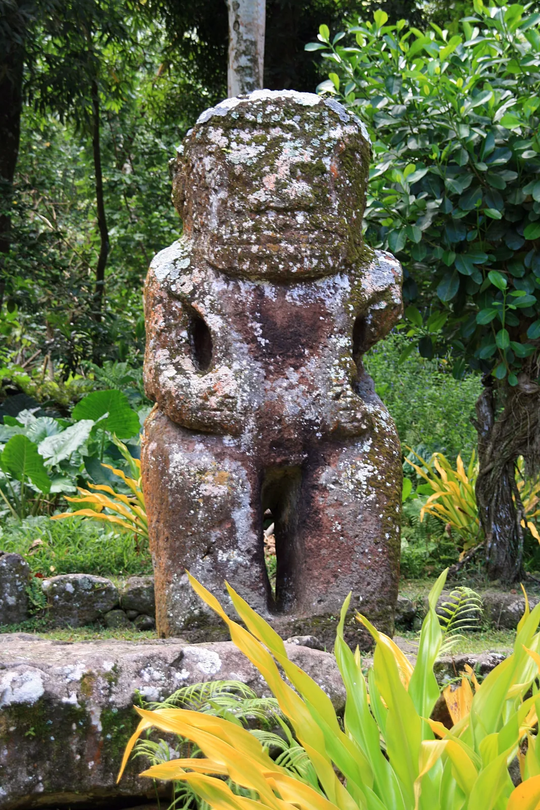 Takaii at Iipona on Hiva Oa, a large reddish stone tiki with bent arms and carved fingers on its rounded abdomen.